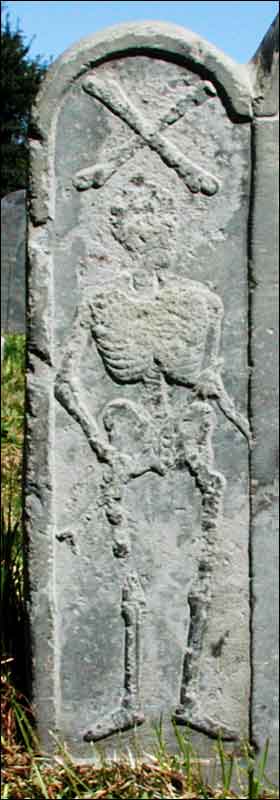 Left border of Tawley stone, with crossbones and Death holding an arrow.